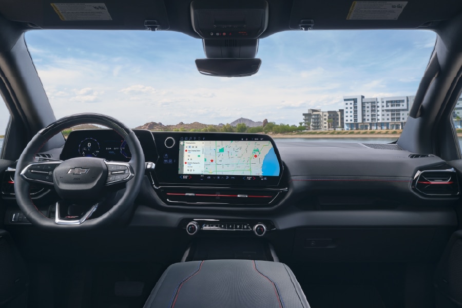 Modern car interior with a large digital display showing navigation against an urban skyline backdrop.